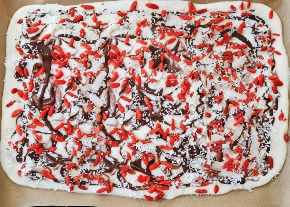 tall tray of coconut yogurt bark with chocolate swirls and goji berries