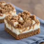 Single cheesecake bar on white plate with whipped cream and candied ginger