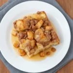 Overhead view of Overnight Apple Crisp Casserole on a plate over slate linen