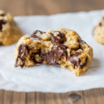 Broken chocolate chip oat cookie showing soft center