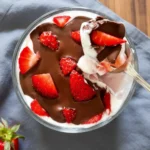 Spoon dipping into strawberry yogurt cup
