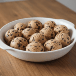 Hand holding a healthy cookie dough bite with chocolate chips
