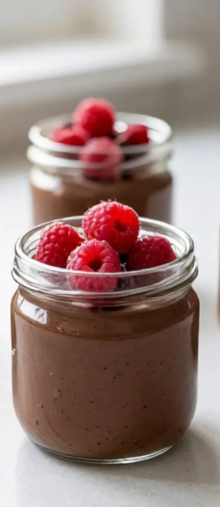 Spoon scooping chocolate tofu dessert from cup